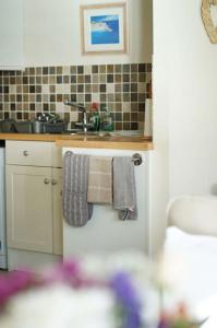 a small kitchen with a sink and towels at The View, Sandown in Sandown
