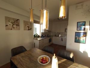 Una cocina con una mesa con un bol de fruta encima. en Helsinki Penthouse near the west harbor, en Helsinki