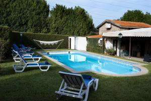 una piscina con tumbonas y una casa en Quinta do Carvalhal Casa Privada, Penafiel, en Irivo