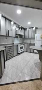 duża kuchnia z białymi szafkami i urządzeniami w obiekcie Comfy 2-Bedrooms Apartment in Cairo 44-2 w Kairze