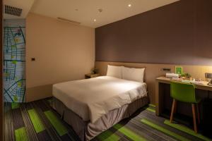 a hotel room with a bed and a desk at Chaiin Hotel - Dongmen in Taipei