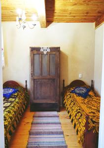 にあるAgroturystyka Prynukaのベッドルーム1室(ベッド2台付)、木製のドアが備わります。