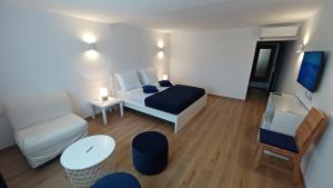 um quarto com uma cama, um sofá e uma mesa em Amaryllis residence, apartment Diana & Deluxe rooms with shared kitchen em Veli Lošinj