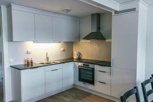 a kitchen with white cabinets and a sink at Loen Apartments in Loen