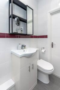 bagno bianco con lavandino e servizi igienici di Taylor's Apartment Wimbledon a Londra