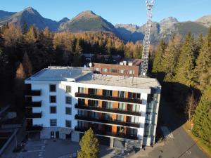 an aerial view of a building with mountains in the background at TATRYSTAY Armeria Apartments in Štrbské Pleso