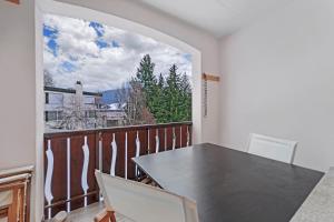 einen Balkon mit einem Tisch und Stühlen sowie einem Fenster in der Unterkunft Abitaziun Belmunt 103 - St Moritz "LOGA ELEGANCE APARTMENT" in St. Moritz