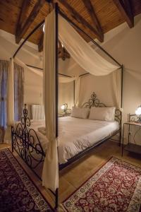 1 dormitorio con cama con dosel y alfombra en Ersis, en Neochori