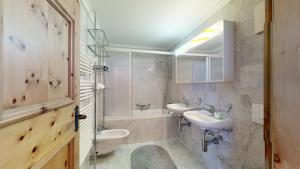 a bathroom with two sinks and a toilet and a tub at Abitaziun Morena 9 - Silvaplana in Silvaplana +14 photos