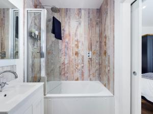 La salle de bains est pourvue d'une baignoire et d'un lavabo. dans l'établissement Driftwood Boutique Guest House, à Rhosneigr