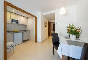 a kitchen and dining room with a table and chairs at Apartamentos Los Tilos in Paguera