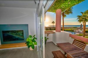 un balcon avec un banc et une vue sur l'océan dans l'établissement Apartasuites Royal Zahara, Máximo confort con vistas al mar, à Zahara de los Atunes