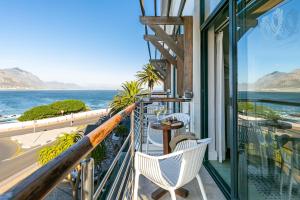 a balcony overlooking a beach with a view of the ocean at Harbour House Hotel in Hermanus