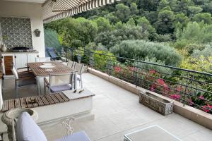 un balcone con tavolo, sedie e fiori di Sea View & Large Terrace LIVE IN LA VISTA a Cannes