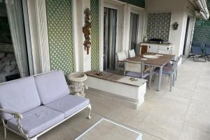 een veranda met een bank en een tafel en stoelen bij Sea View & Large Terrace LIVE IN LA VISTA in Cannes
