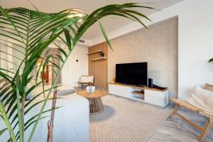 ein Wohnzimmer mit einem TV und einer großen Anlage in der Unterkunft Bright Nordic style penthouse in beachside resort in Marbella
