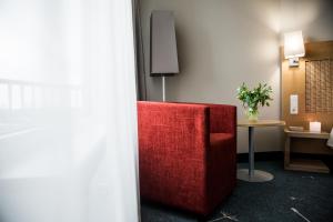 a red chair in a room with a table at Georg Ots Spa Hotel in Kuressaare