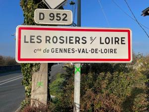 un panneau rouge et blanc sur une route dans l'établissement Logis Loire Hotel - Les Cocottes Restaurant, à Les Rosiers