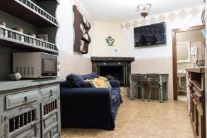 salon z niebieską kanapą i kominkiem w obiekcie Casa Cueva Picoesquina w mieście Guadix