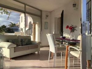 a living room with a couch and a table and chairs at Villa Antonia con piscina privada AC y wifi in Tarragona