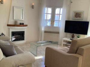 a living room with a fireplace and a tv at Villa Antonia con piscina privada AC y wifi in Tarragona