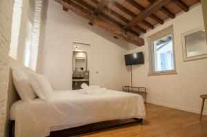 a white bedroom with a white bed and a window at Umbrian Concierge - La Corte del Grillo in Perugia