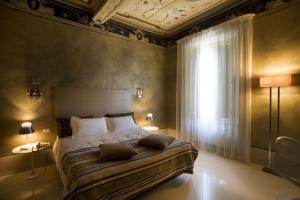 Un pat sau paturi într-o cameră la Palazzo Bontadosi Hotel & Spa
