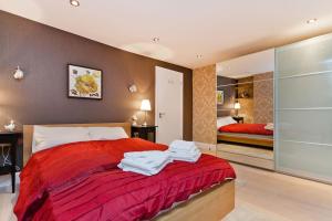a bedroom with a red bed with towels on it at Whole house in Central Camden Town in London