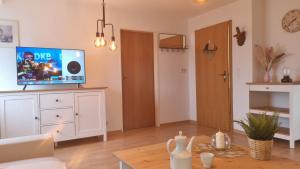 a living room with a flat screen tv on a dresser at Appartement im Silwai 4 in Westerland