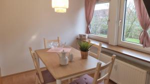 a dining room table and chairs with a table and window at Appartement im Silwai 4 in Westerland