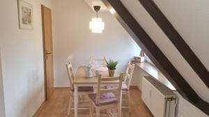 a table and chairs in a room with an attic at Appartement im Silwai 4 in Westerland