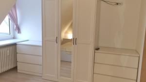 a white closet with glass doors in a room at Appartement im Silwai 4 in Westerland