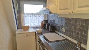 a small kitchen with a sink and a window at Appartement im Silwai 4 in Westerland +1 photo