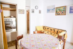 a dining room with a table and a stove at Loft Seccheto sul Mare in Seccheto