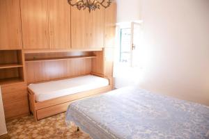 a small bedroom with a bed and wooden cabinets at Loft Seccheto sul Mare in Seccheto
