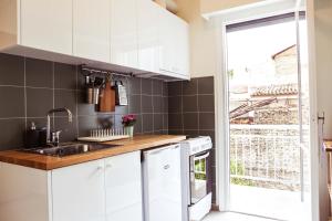 a kitchen with white cabinets and a sink at ViLLaRa: Style, Hospitality & Design (City Center) in Athens