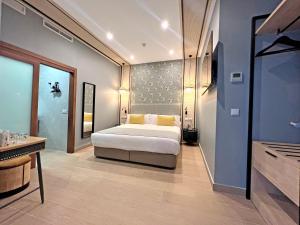 a bedroom with a large bed and a bathroom at Soho Boutique Columela in Cádiz