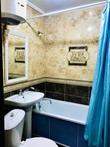 a bathroom with a sink and a tub and a toilet at Apartaments in the city center in Karagandy