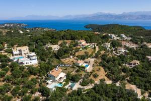 una vista aérea de una casa en una colina junto al agua en Villa Firefly by Villa Plus en Ágios Stéfanos