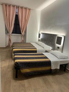 um quarto com 2 camas e uma janela em Hotel principe em Roma
