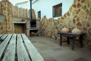 Habitación de piedra con banco y chimenea de piedra en Casa Cueva Picoesquina, en Guadix