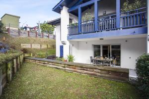 a house with a blue balcony on top of it at Comfortable apartment with terrace and garden - Welkeys in Bidart