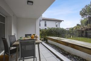 a patio with a table and chairs on a balcony at Comfortable apartment with terrace and garden - Welkeys in Bidart