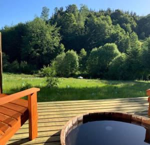 a wooden deck with a pond and a wooden bridge at "Refugio Pulli" Tierra y naturaleza in Villarrica