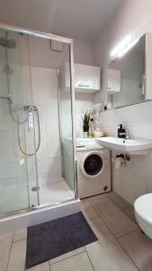 y baño con ducha y lavadora. en Apartament SREBRNY Krakowskie Przedmieście 26, en Lublin