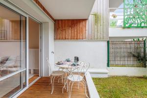 a patio with a table and chairs on a balcony at Appartement Delacroix - Welkeys in La Rochelle