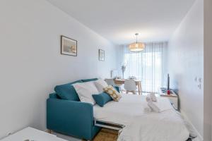 a bedroom with a blue couch and a table at Appartement Delacroix - Welkeys in La Rochelle