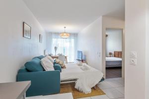 a living room with a blue couch and a bathroom at Appartement Delacroix - Welkeys in La Rochelle
