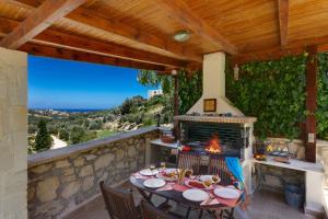 a patio with a table and a fireplace at Villa Katia Faragi by Villa Plus in Giannoudi