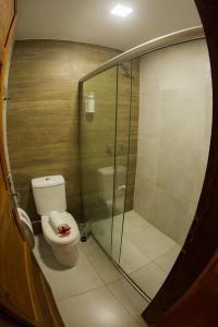 a bathroom with a toilet and a glass shower at Pousada Fortaleza in Fernando de Noronha